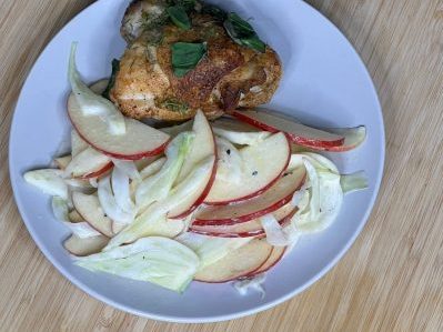 Pazazz fennel slaw and roasted chicken sitting on a white plate